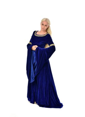 tam uzunlukta bir mavi fantezi Ortaçağ elbisesi giymiş güzel sarışın kadın portresi. Beyaz arka plan üzerinde ayakta poz.