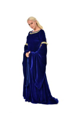 tam uzunlukta bir mavi fantezi Ortaçağ elbisesi giymiş güzel sarışın kadın portresi. Beyaz arka plan üzerinde ayakta poz.