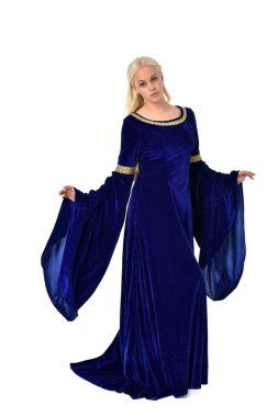 tam uzunlukta bir mavi fantezi Ortaçağ elbisesi giymiş güzel sarışın kadın portresi. Beyaz arka plan üzerinde ayakta poz.