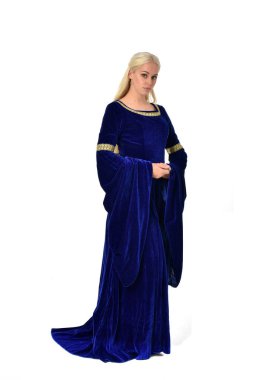 tam uzunlukta bir mavi fantezi Ortaçağ elbisesi giymiş güzel sarışın kadın portresi. Beyaz arka plan üzerinde ayakta poz.