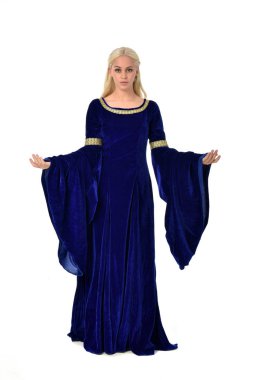 tam uzunlukta bir mavi fantezi Ortaçağ elbisesi giymiş güzel sarışın kadın portresi. Beyaz arka plan üzerinde ayakta poz.