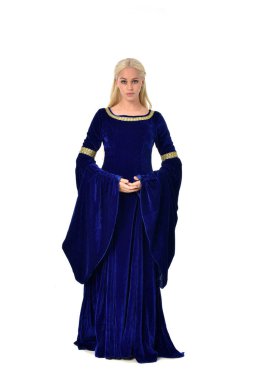 tam uzunlukta bir mavi fantezi Ortaçağ elbisesi giymiş güzel sarışın kadın portresi. Beyaz arka plan üzerinde ayakta poz.