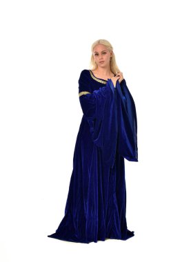 tam uzunlukta bir mavi fantezi Ortaçağ elbisesi giymiş güzel sarışın kadın portresi. Beyaz arka plan üzerinde ayakta poz.