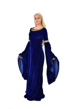 tam uzunlukta bir mavi fantezi Ortaçağ elbisesi giymiş güzel sarışın kadın portresi. Beyaz arka plan üzerinde ayakta poz.