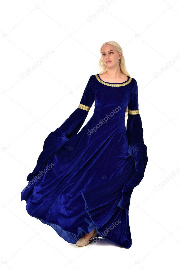 full length portrait of pretty blonde lady wearing  a blue fantasy medieval gown. standing pose on white background.