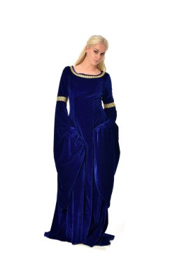 tam uzunlukta bir mavi fantezi Ortaçağ elbisesi giymiş güzel sarışın kadın portresi. Beyaz arka plan üzerinde ayakta poz.