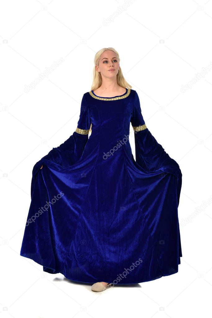 full length portrait of pretty blonde lady wearing  a blue fantasy medieval gown. standing pose on white background.