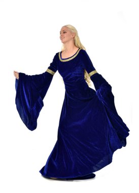 tam uzunlukta bir mavi fantezi Ortaçağ elbisesi giymiş güzel sarışın kadın portresi. Beyaz arka plan üzerinde ayakta poz.