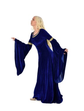 tam uzunlukta bir mavi fantezi Ortaçağ elbisesi giymiş güzel sarışın kadın portresi. Beyaz arka plan üzerinde ayakta poz.