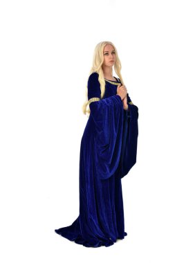 tam uzunlukta bir mavi fantezi Ortaçağ elbisesi giymiş güzel sarışın kadın portresi. Beyaz arka plan üzerinde ayakta poz.