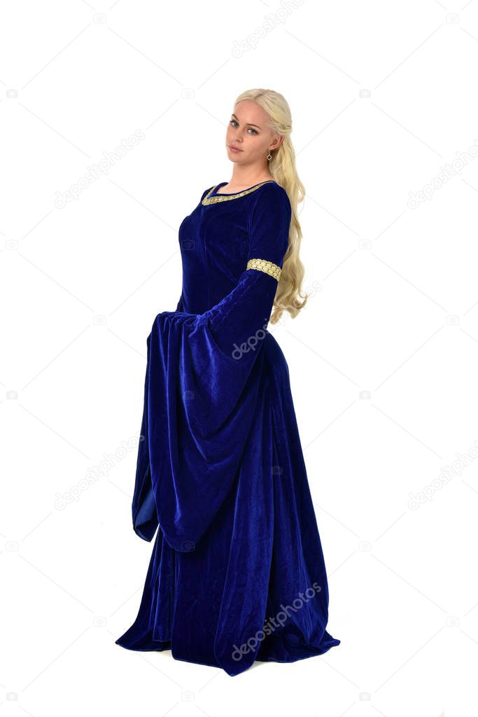 full length portrait of pretty blonde lady wearing  a blue fantasy medieval gown. standing pose on white background.