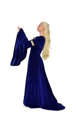 full length portrait of pretty blonde lady wearing  a blue fantasy medieval gown. standing pose on white background. clipart