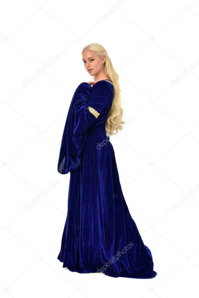 full length portrait of pretty blonde lady wearing  a blue fantasy medieval gown. standing pose on white background.