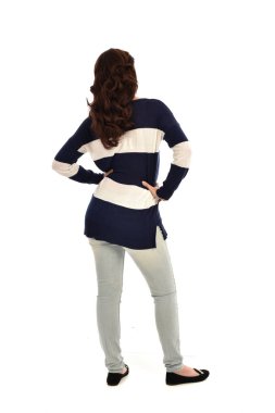 Tam boy kot pantolon ve rahat bir jumper giyen kız portresi. ayakta poz, beyaz stüdyo arka plan üzerinde izole.