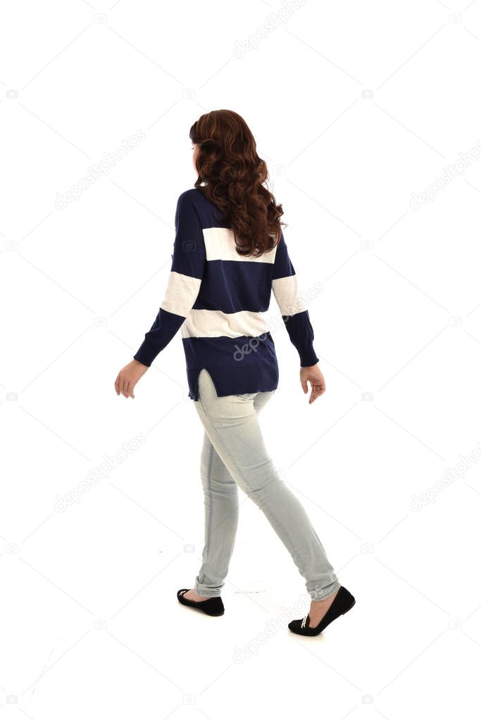 full length portrait of girl wearing jeans and a casual jumper. standing pose, isolated on white studio background.