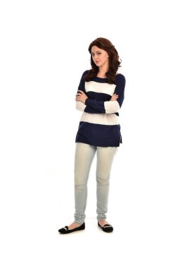 Tam boy çizgili mavi ve beyaz jumper ve kot giyen kız portresi. beyaz stüdyo arka plan üzerinde ayakta poz.