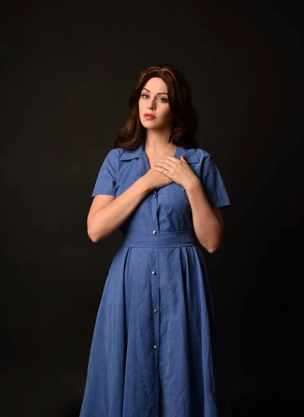 青いドレスを着ているブルネットの女性の肖像画 黒のスタジオの背景にもたらされる — ストック写真