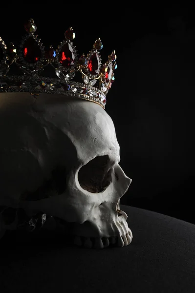 黒い背景に赤と金の宝石の王冠 身に着けている人間の頭蓋骨のクローズ アップ — ストック写真