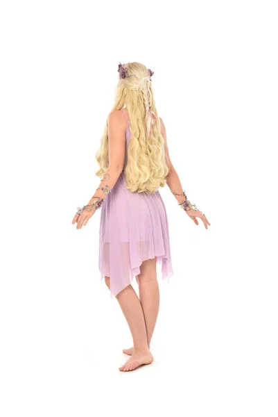 紫のドレスを着ている金髪の女の子の完全な長さの肖像画 ホワイト スタジオの背景に分離カメラから離れて直面している立ちポーズ — ストック写真