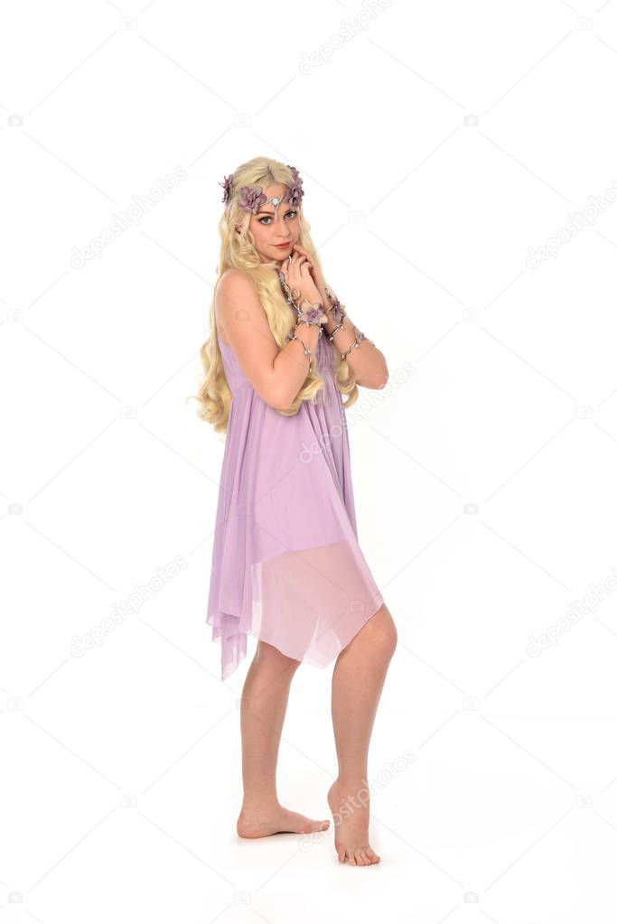 full length portrait of blonde girl wearing purple fairy costume. standing pose, isolated on white studio background.
