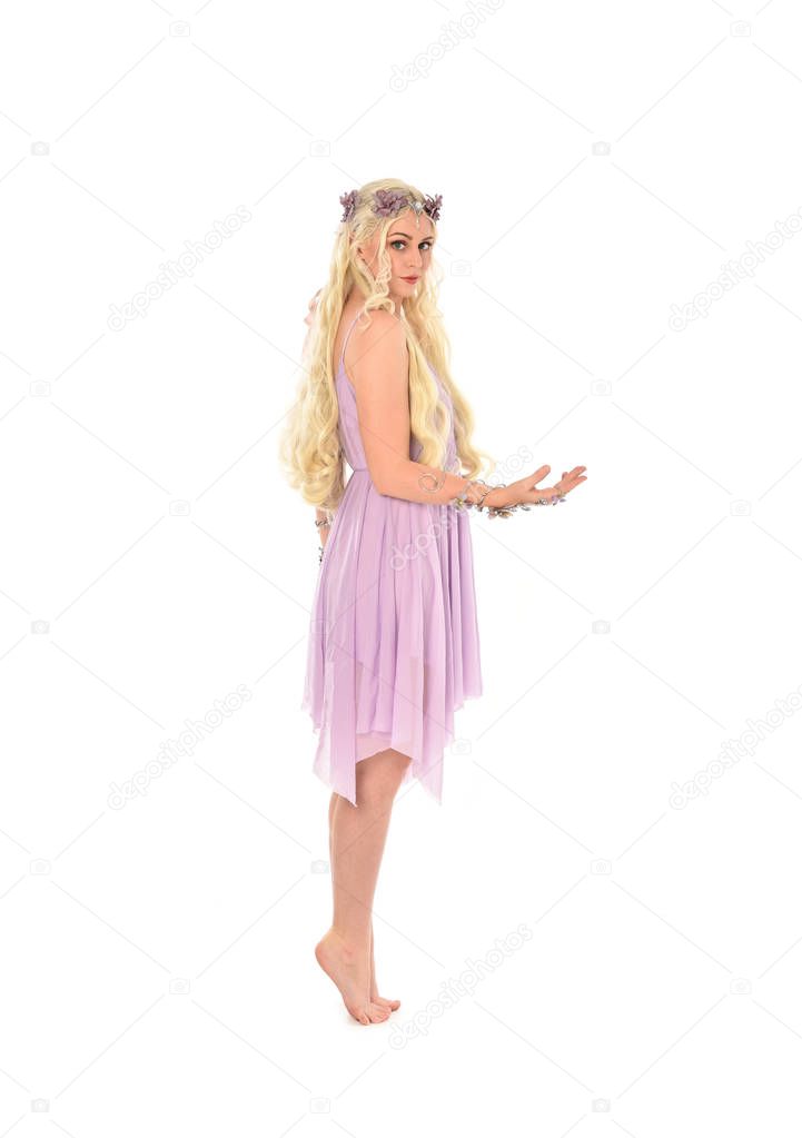 full length portrait of blonde girl wearing purple fairy costume. standing pose, isolated on white studio background.