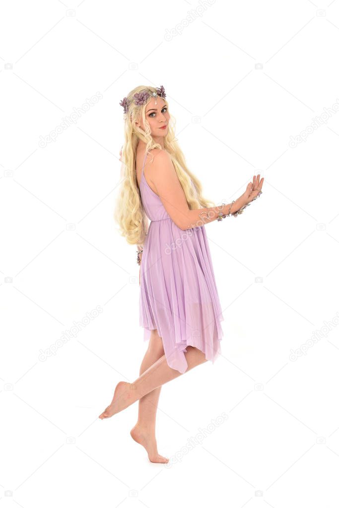 full length portrait of blonde girl wearing purple fairy costume. standing pose, isolated on white studio background.