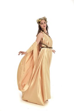 Tam boy poz ayakta altın Yunan elbisesi giymiş esmer kadın portresi. beyaz stüdyo arka plan üzerinde izole.