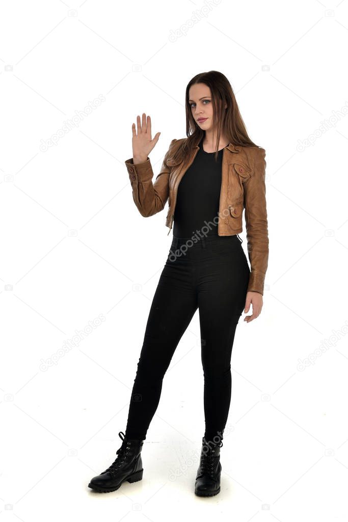 full length portrait of brunette girl wearing brown leather jacket.   standing pose on white background.