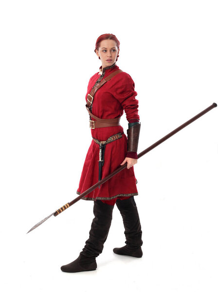 full length portrait of red haired girl wearing fantasy medieval costume, standing pose on studio background.