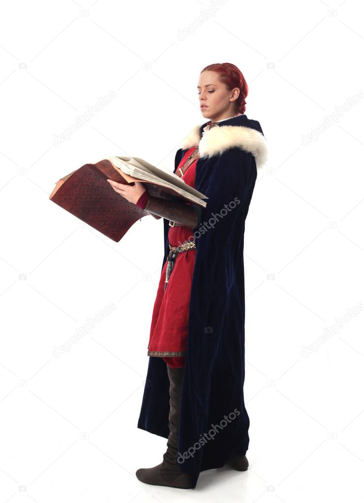 full length portrait of red haired girl wearing fantasy medieval costume, standing pose on studio background.