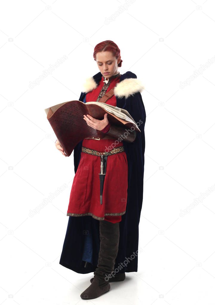 full length portrait of red haired girl wearing fantasy medieval costume, standing pose on studio background.