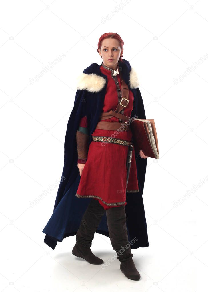 full length portrait of red haired girl wearing fantasy medieval costume, standing pose on studio background.