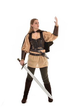 tam uzunlukta portre sarışın kız kahverengi Ortaçağ savaşçı kostüm giyiyor. ayakta poz, beyaz stüdyo arka plan üzerinde izole.