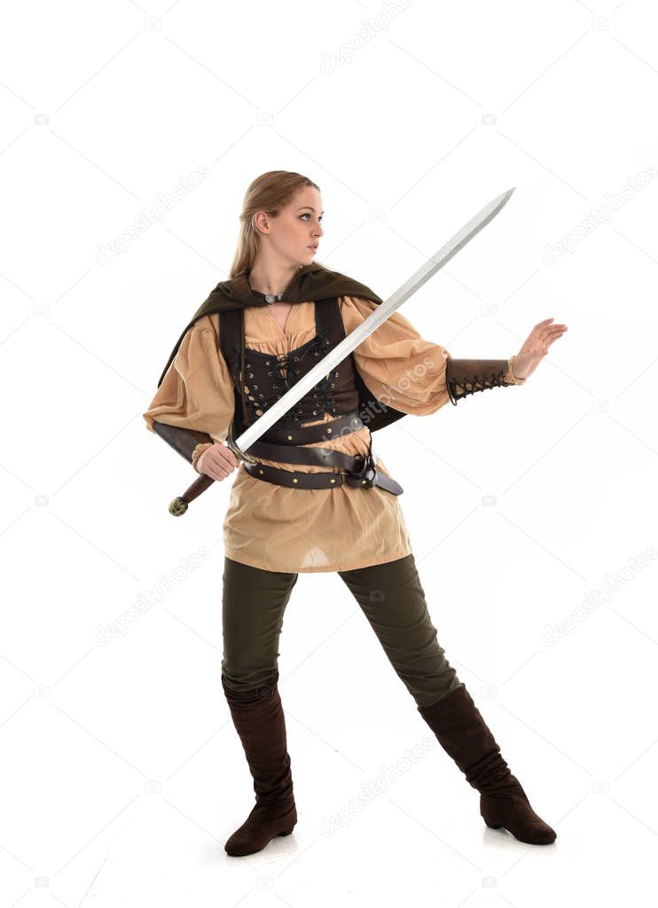 full length portrait of blonde girl wearing brown medieval warrior costume. standing pose, isolated on white studio background.