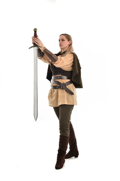 茶色の中世の戦士の衣装を着て ブロンドの女の子の完全な長さの肖像画 立ちポーズ 白いスタジオ背景に分離 — ストック写真