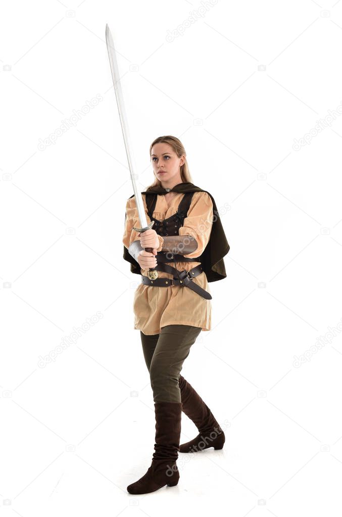full length portrait of blonde girl wearing brown medieval warrior costume. standing pose, isolated on white studio background.