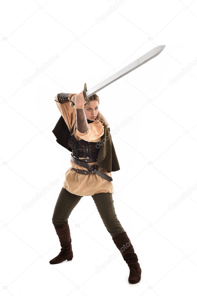 full length portrait of blonde girl wearing brown medieval warrior costume. standing pose, isolated on white studio background.