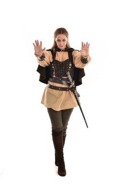 tam uzunlukta portre sarışın kız kahverengi Ortaçağ savaşçı kostüm giyiyor. ayakta poz, beyaz stüdyo arka plan üzerinde izole.