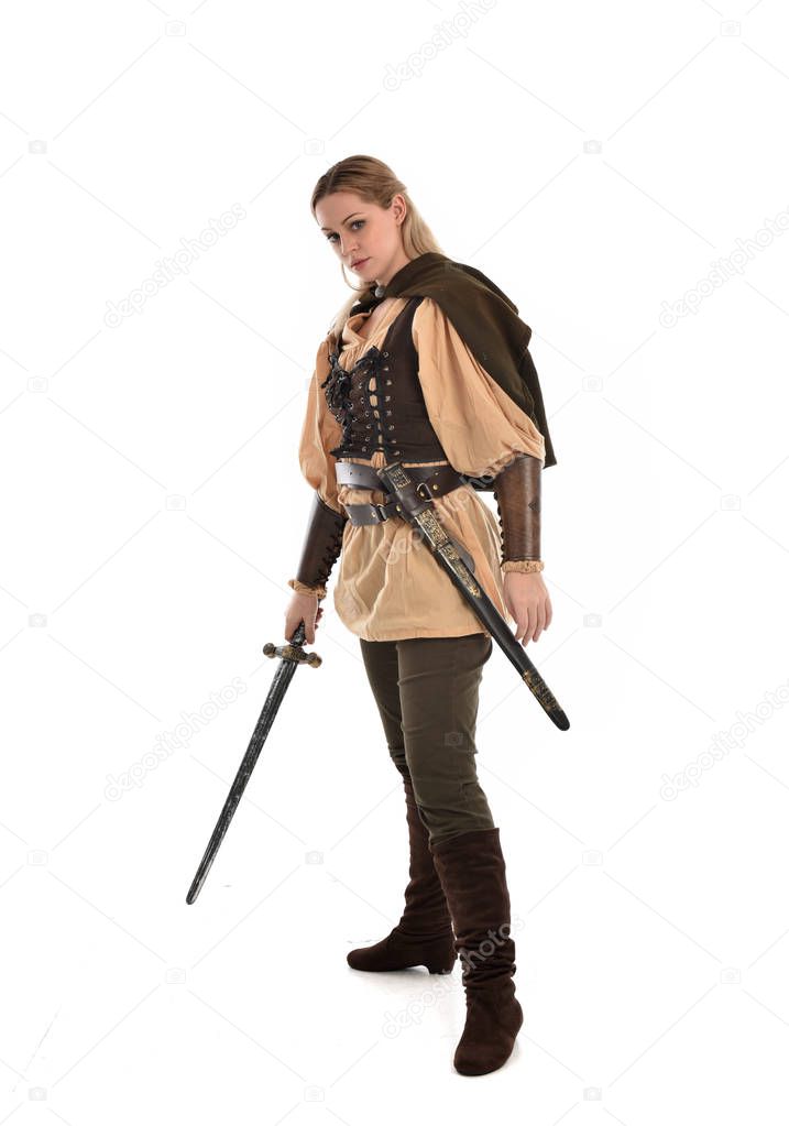 full length portrait of blonde girl wearing brown medieval warrior costume. standing pose, isolated on white studio background.