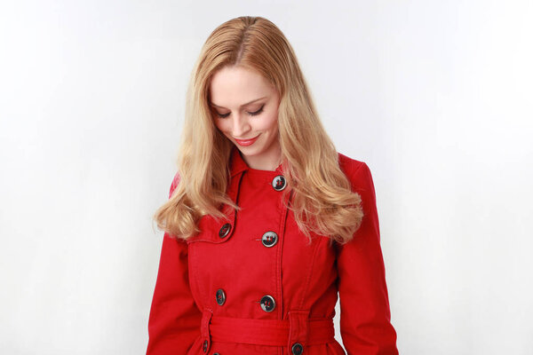 портрет красивой блондинки в красном плаще. изолированные на белом фоне студии
.