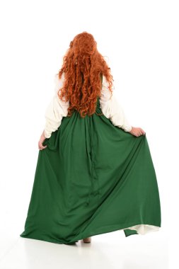 tam uzunlukta yeşil Ortaçağ elbisesi giymiş kırmızı saçlı kız portresi. beyaz stüdyo arka plan üzerinde ayakta poz.