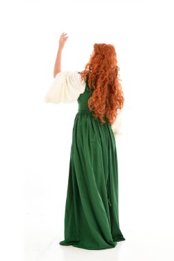 tam uzunlukta yeşil Ortaçağ elbisesi giymiş kırmızı saçlı kız portresi. beyaz stüdyo arka plan üzerinde ayakta poz.