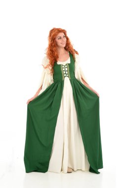 poz ayakta yeşil Ortaçağ elbisesi, tam uzunlukta kırmızı saçlı kız giyiyor. beyaz stüdyo arka plan üzerinde izole.