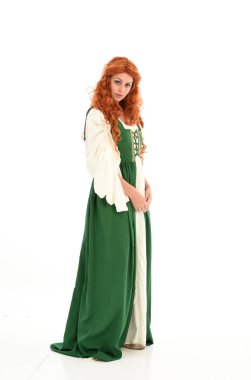 poz ayakta yeşil Ortaçağ elbisesi, tam uzunlukta kırmızı saçlı kız giyiyor. beyaz stüdyo arka plan üzerinde izole.