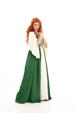 poz ayakta yeşil Ortaçağ elbisesi, tam uzunlukta kırmızı saçlı kız giyiyor. beyaz stüdyo arka plan üzerinde izole.