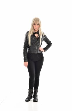 tam uzunlukta portre sarışın kız siyah deri elbiseler giymiş poz ayakta. beyaz stüdyo arka plan üzerinde izole.