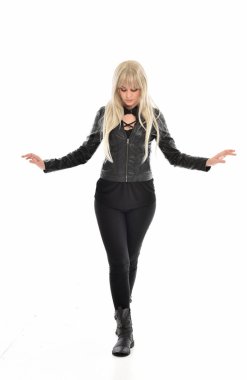 tam uzunlukta portre sarışın kız siyah deri elbiseler giymiş poz ayakta. beyaz stüdyo arka plan üzerinde izole.