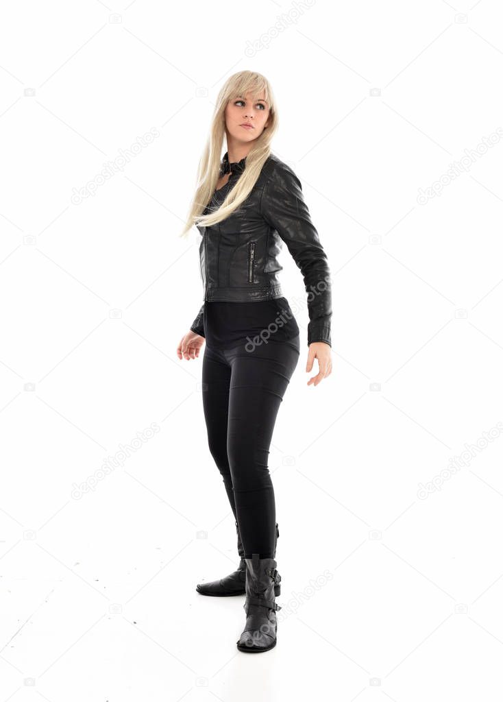 full length portrait of blonde girl wearing black leather clothes, standing pose.  isolated on white studio background.