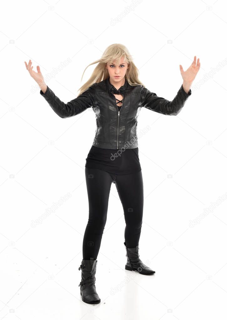 full length portrait of blonde girl wearing black leather clothes, standing pose.  isolated on white studio background.