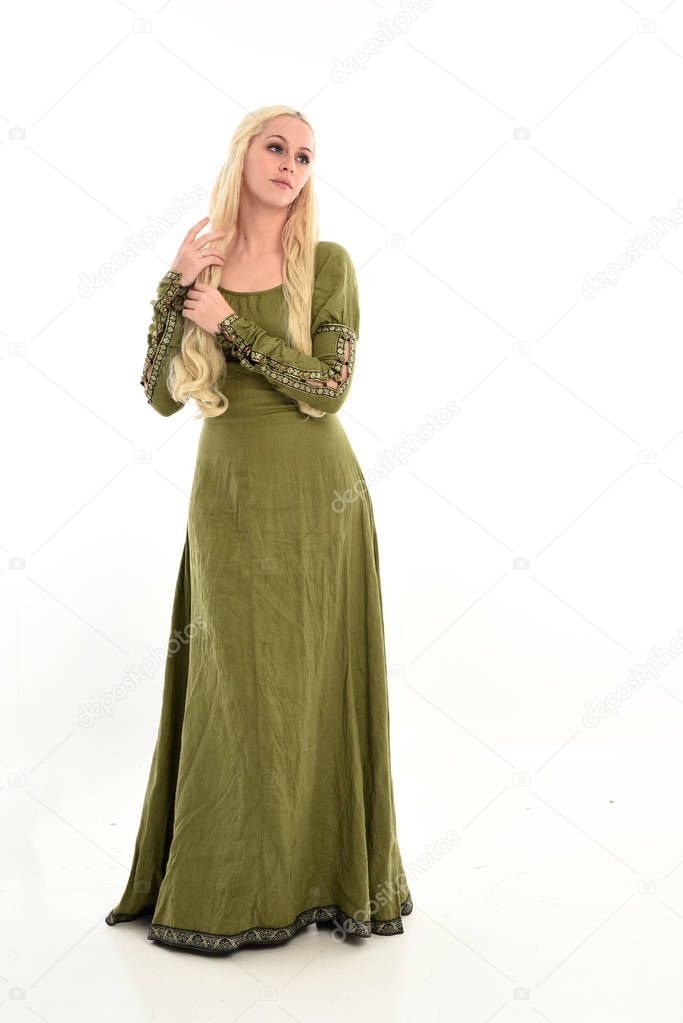 full length portrait of blonde girl wearing long, green, medieval gown. standing pose, isolated on white studio background.